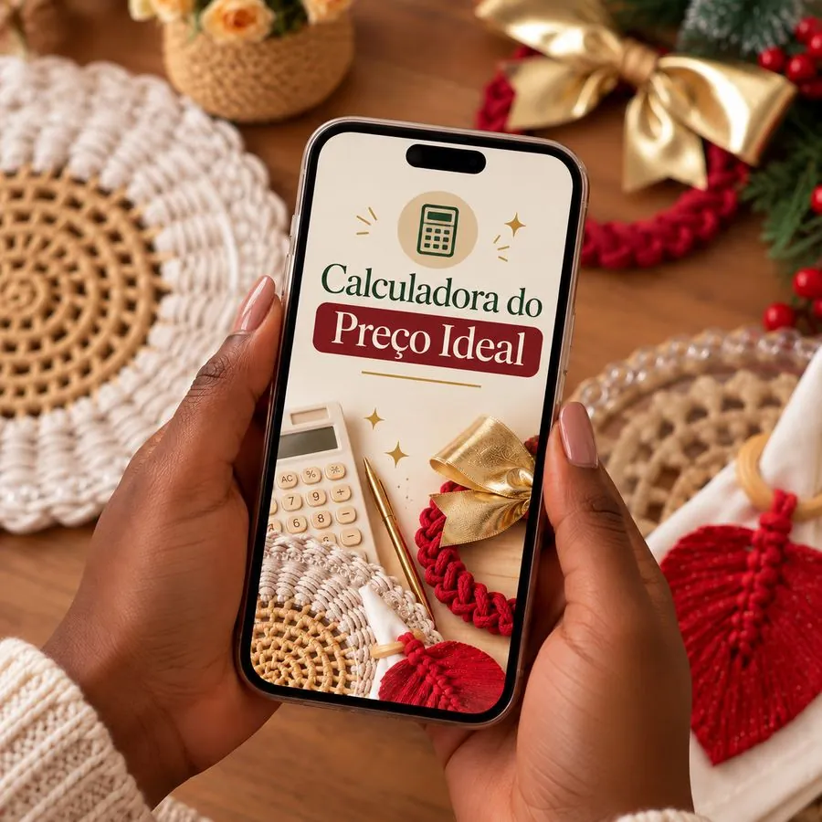 Mãos segurando o celular com a Calculadora do Preço Ideal aberta, ao lado de peças de Natal em macramê